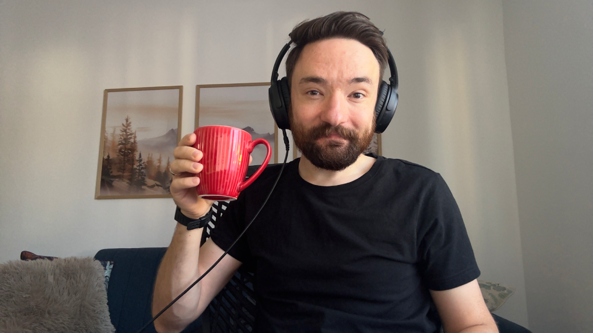 Razvan Muntian wearing headphones and holding a coffee mug